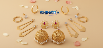 A flat-lay collection of Shinexa gold-plated earrings featuring traditional gold Jhumkas with pearls, red stone Chandrakor studs, modern geometric danglers, and classic gold hoops on a soft beige background with rose petals.