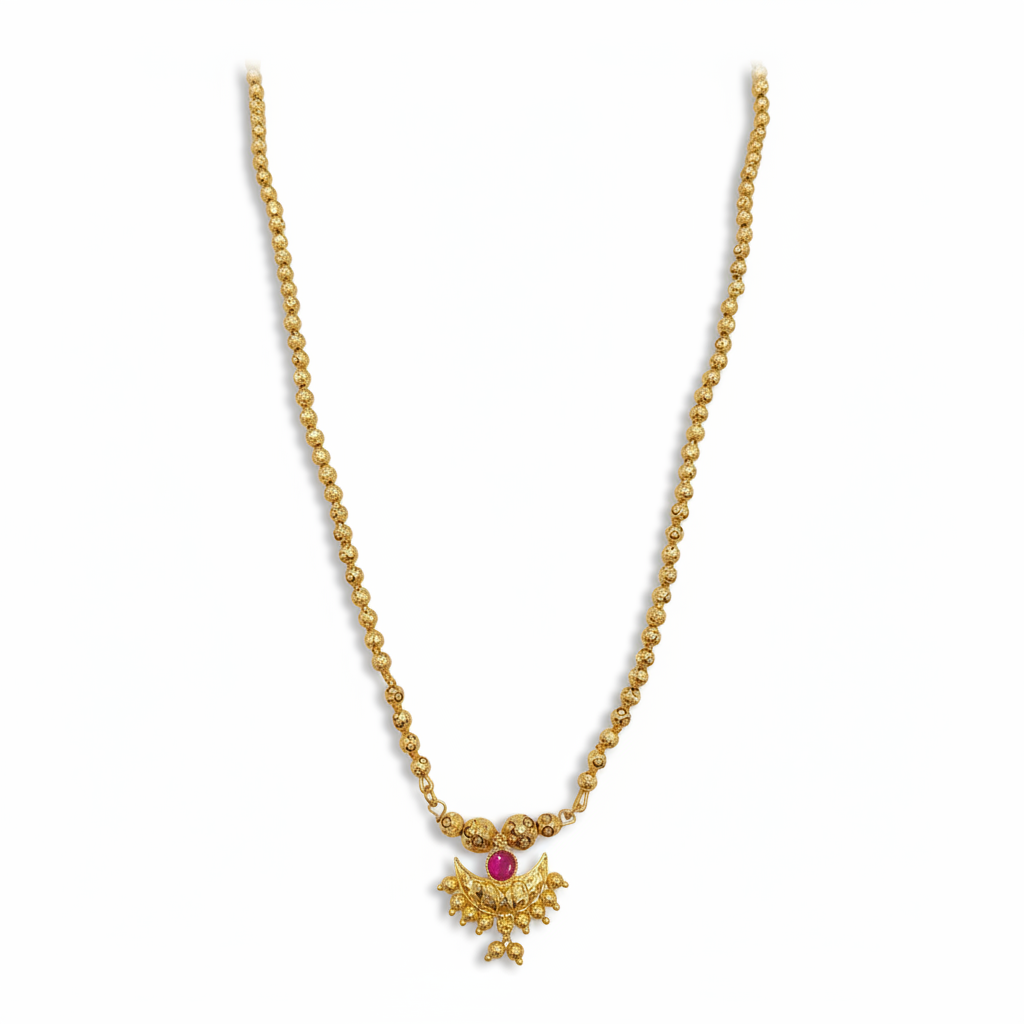 Gold necklace with a red gemstone pendant on a white background