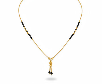 Fancy gold plated mangalsutra with black beads on a white background